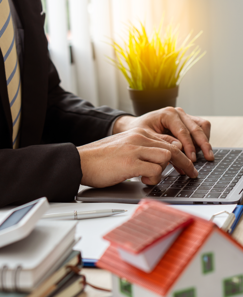 "Una mano protegiendo una casa de juguete contra la caída de bloques de madera, simbolizando la seguridad financiera y la protección del hogar."